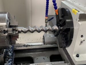 High-efficiency rotor milling on a CNC lathe using a dedicated tool post for complex geometry progressive cavity pump components.