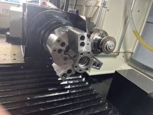 Close-up of the precision workpiece spindle and clamping chuck holding a metal component on the SMK1503 CNC Thread Grinding Machine.
