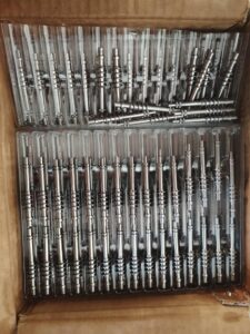 A display of several complex metal parts machined with high precision by the MX500 whirling machine. These parts feature a high surface finish and intricate details, highlighting the machine's advanced manufacturing capabilities, arranged against a clean, industrial background.