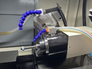 Detailed view of the high-speed grinding spindle, abrasive wheel, adjustable A-axis base, and coolant nozzles on the SMK1503 CNC Thread Grinding Machine.