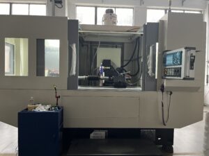 A wide, full shot of the entire SMK1507 CNC Thread Grinding Machine showing its complete enclosure, large glass window with a workpiece inside, and the operator's control panel on the right. A tool cart is in the foreground.