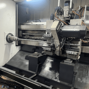 Close-up of a high-speed whirling milling cutter head with carbide inserts machining a precision thread on a metal shaft.
